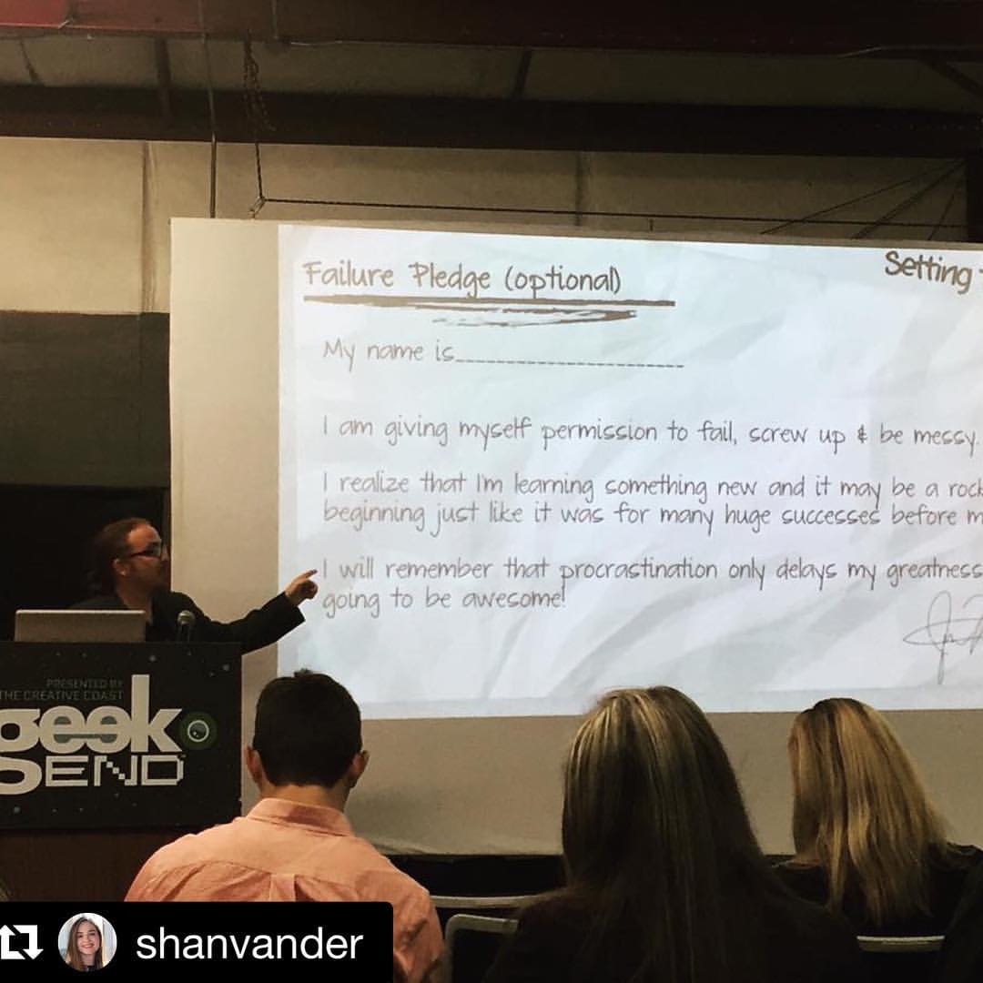 Ben presenting the Failure Pledge at Geek Send, pointing at the projected slide while three people watch from the audience.